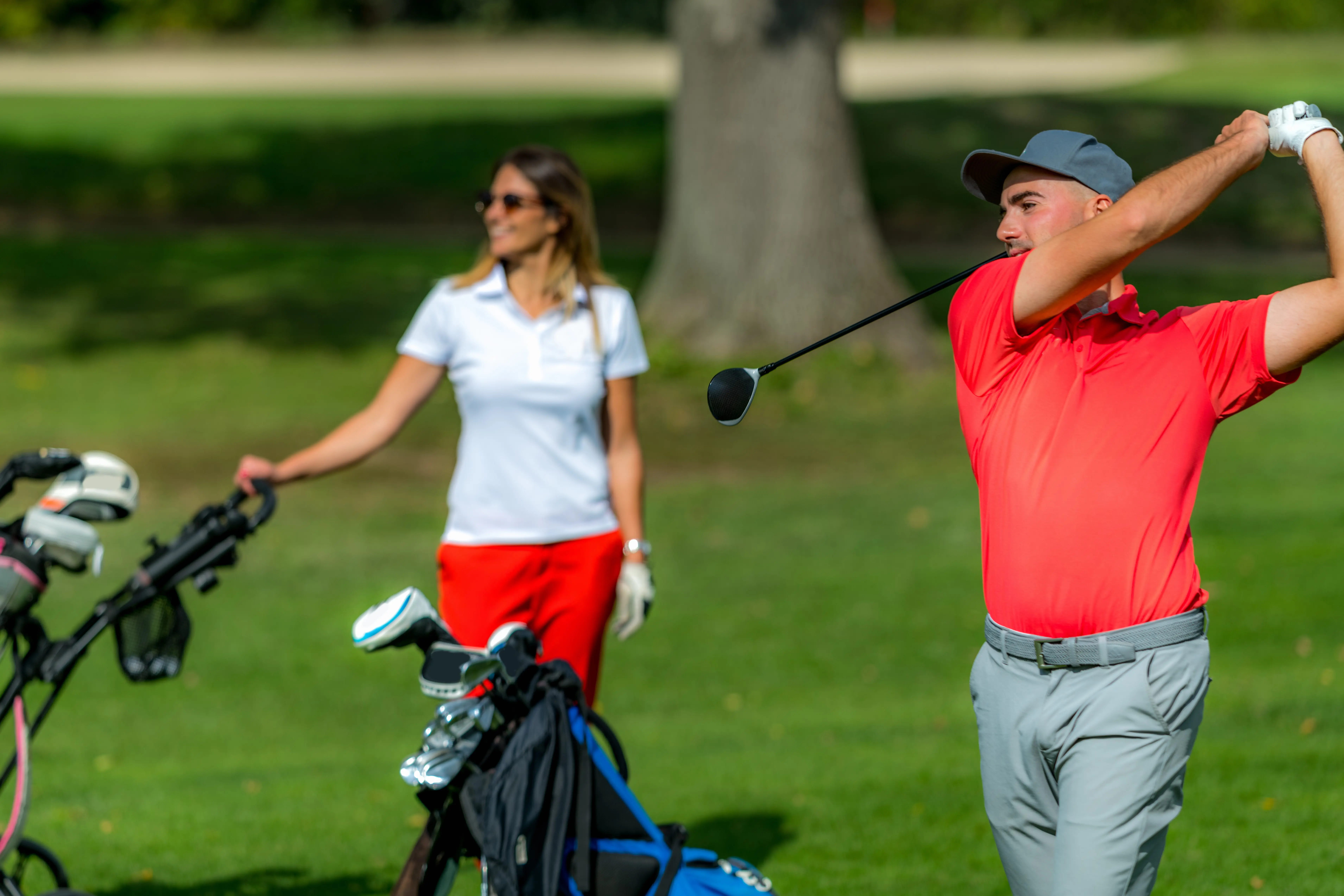 A happy couple of golfers on a golf course.