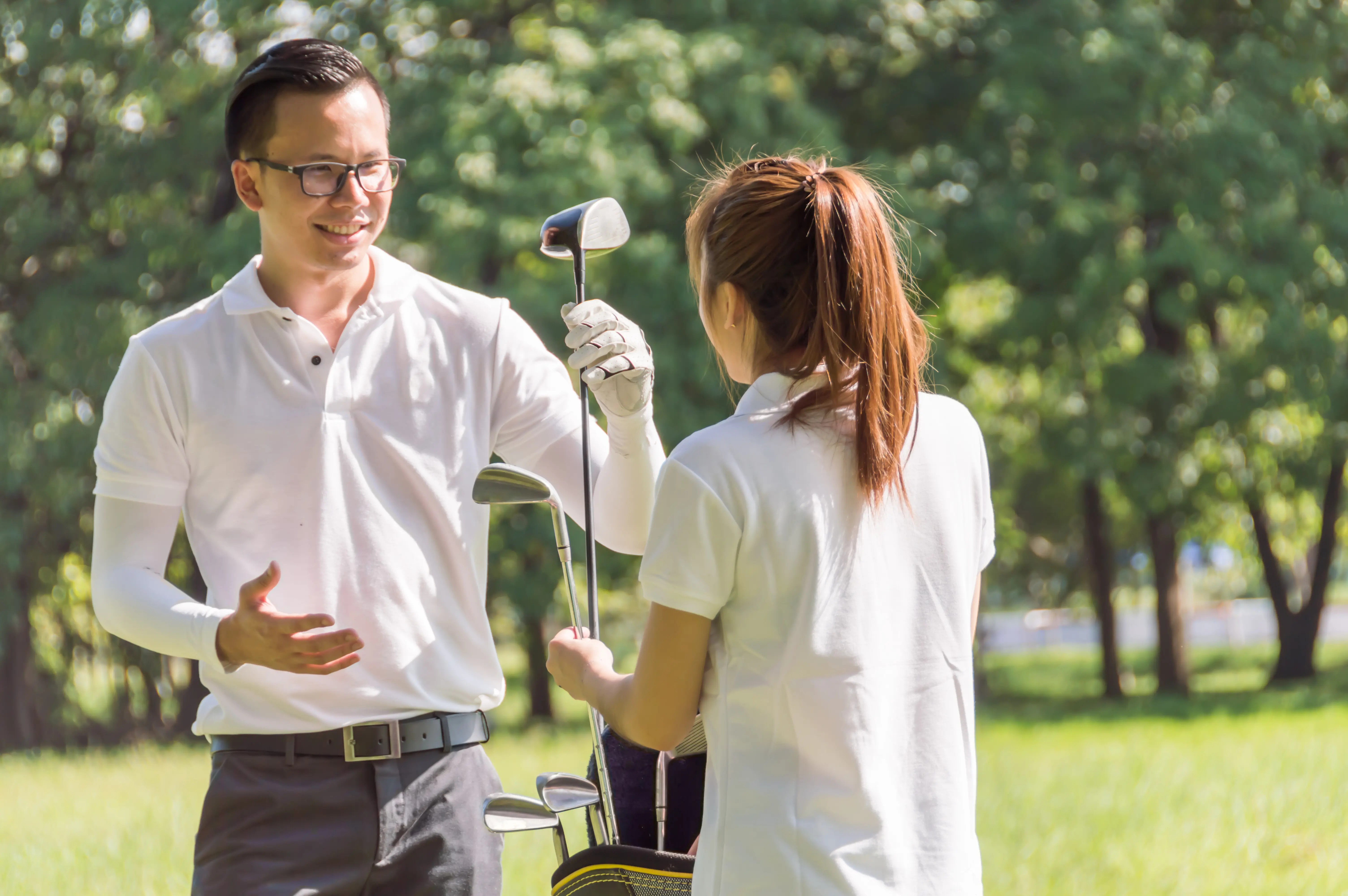 Golfers are selecting golf clubs.